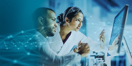 Two researcher looking into a screen